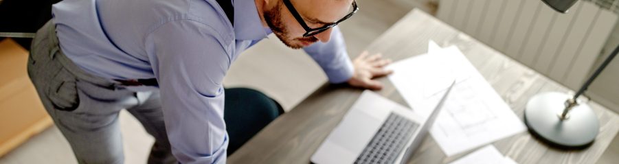 Top view of young architect, thinking about new project, he is lean on the table. Work at home.