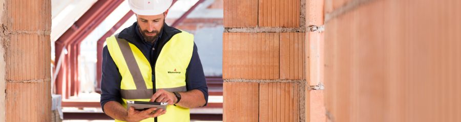Product manager standing in attic under renovation checking tablet