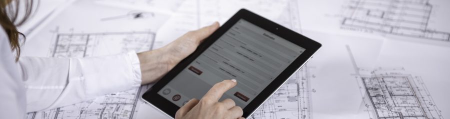 Woman at workplace with blueprint holding tablet computer, Fast Forward Commercial Excellence