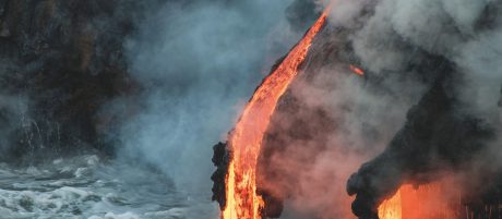 Molten lava flowing into the Pacific Ocean on Big Island of Hawaii at sunrise