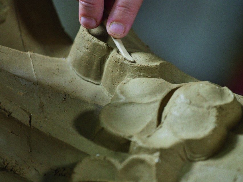 Worker in the manufactory buchwaeldchen shaping a special brick