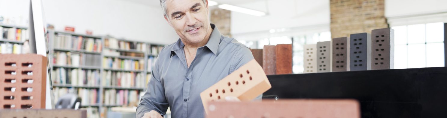 Architect with tablet presenting tablet to end customer at studio in attic loft