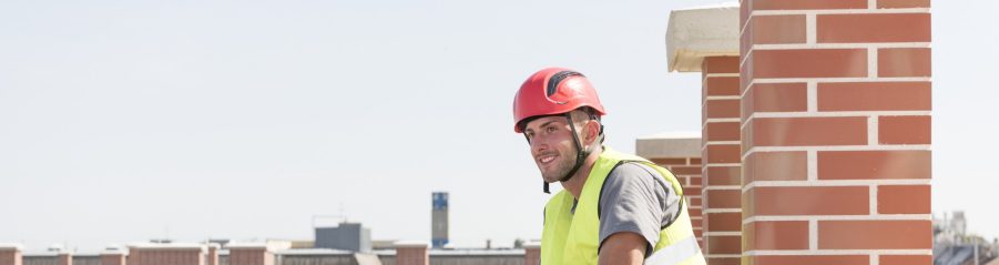 Smiling roofer sitting on roof