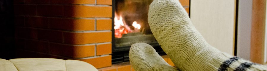 Someone sitting in the front of fireplace.