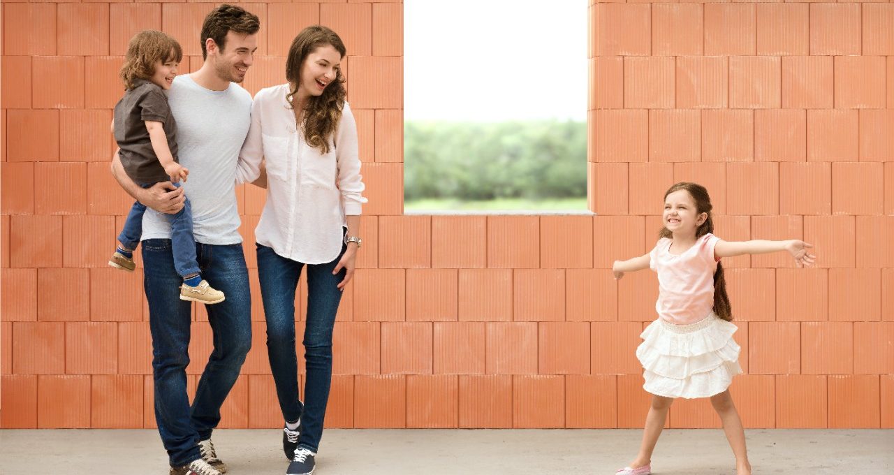 Parents watching girl in joy over her future room in building shell