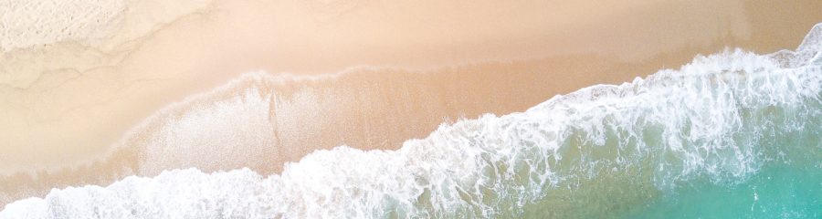 Aerial view of sandy beach and ocean with waves
