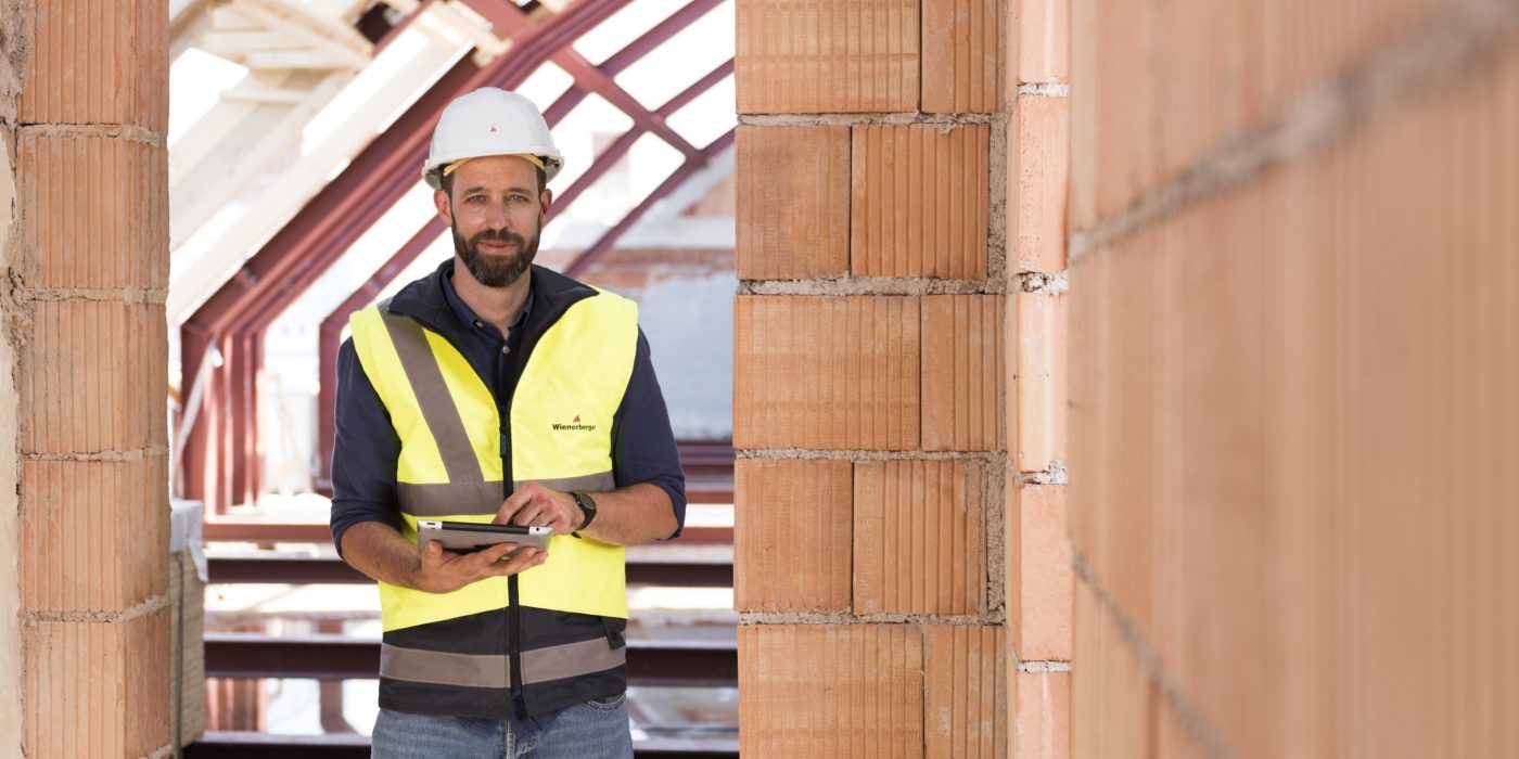 Product manager standing in attic under renovation holding iPad
