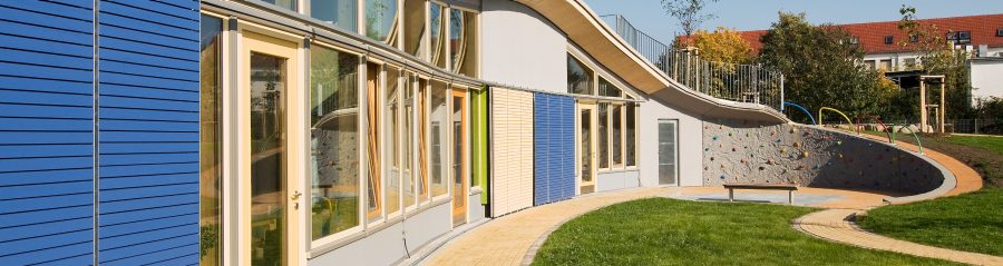 A children's day-care centre from the outside, a green area and the entrance area can be seen, T8-36,5-P