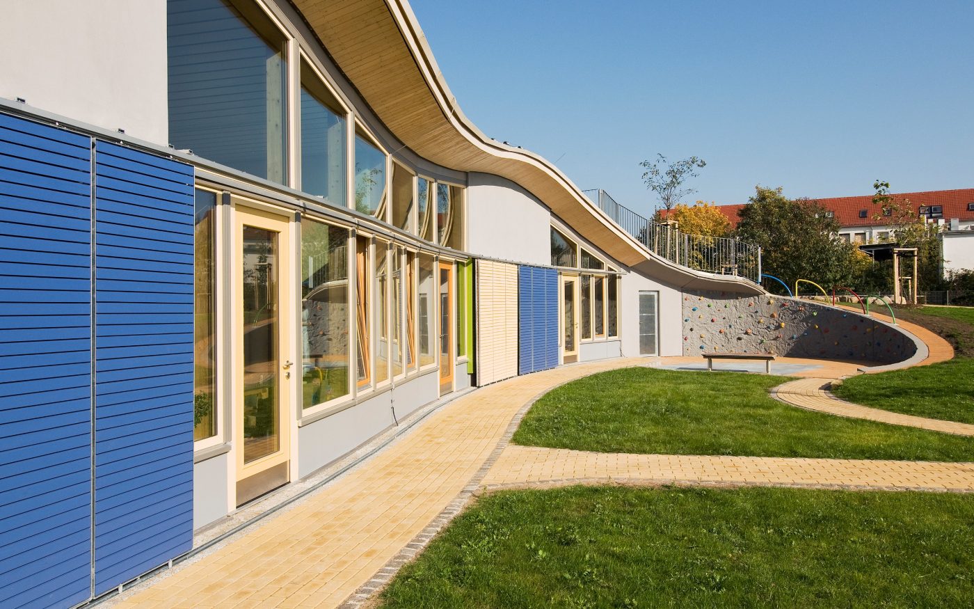 A children's day-care centre from the outside, a green area and the entrance area can be seen, T8-36,5-P