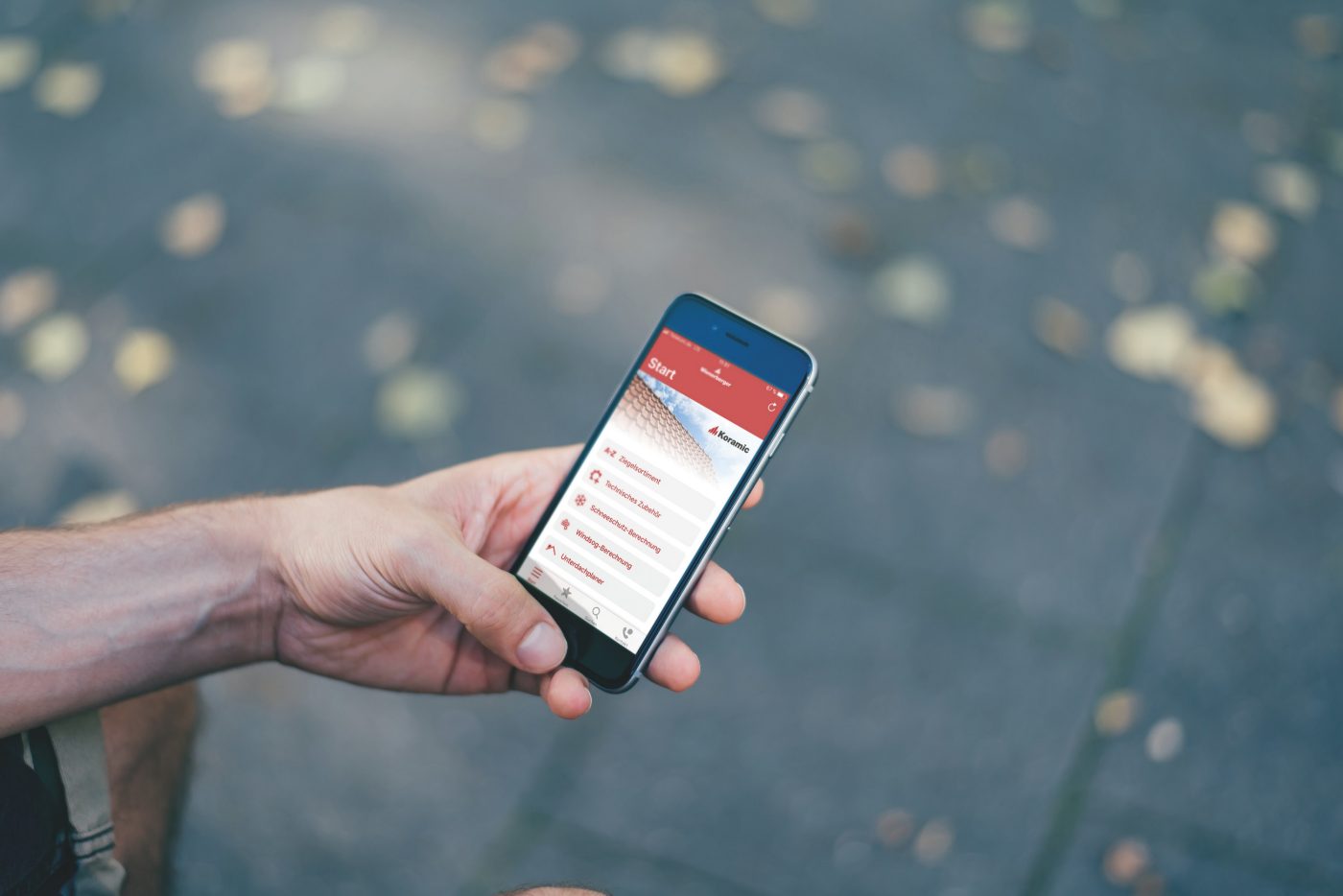 Male hand holding iPhone with Koramic App