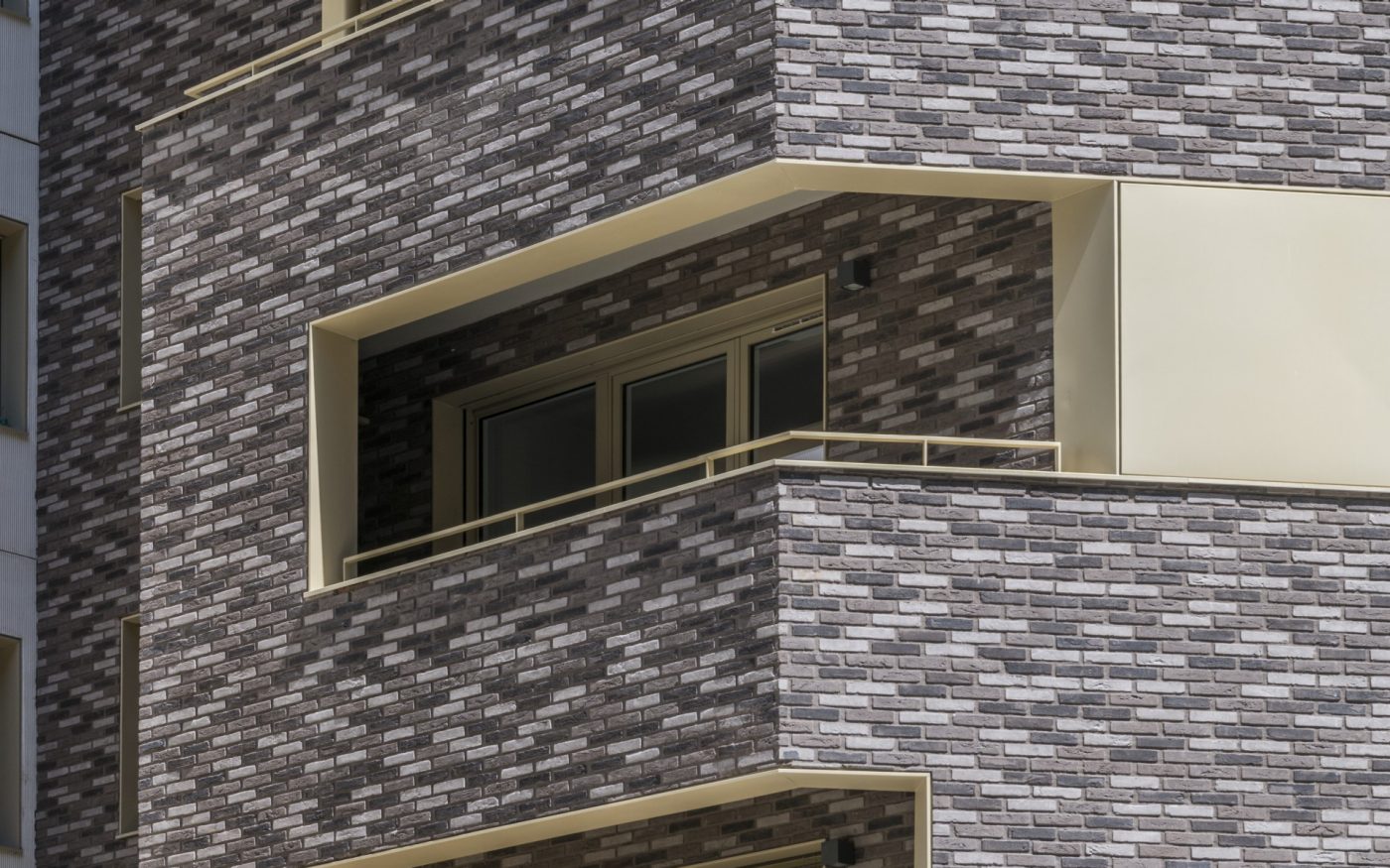 Building with apartments and one-family housings. Buiding with warm colours and a green roof. Immeuble Allure, 66 rue Mstislav Rostropovitch 75017 PARIS. Brick Terca KESS and Ligne Moulée Main Elmore, Forum Cromo, Nero Zwart Mangaan.