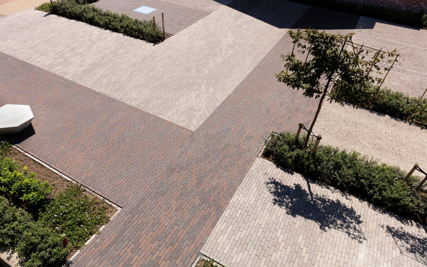 Apotheek Debruyne-Desrumaux, Apothekenvorplatz, Parkplatz, Freiflächen, Platzgestaltung, Aquata, Pflasterklinker, wasserdurchlässig, versickerungsfähig, Läuferverband, Landschaftsgestaltung, Brügge, Belgien, Watelle tuinen & landschappen, Oedelem