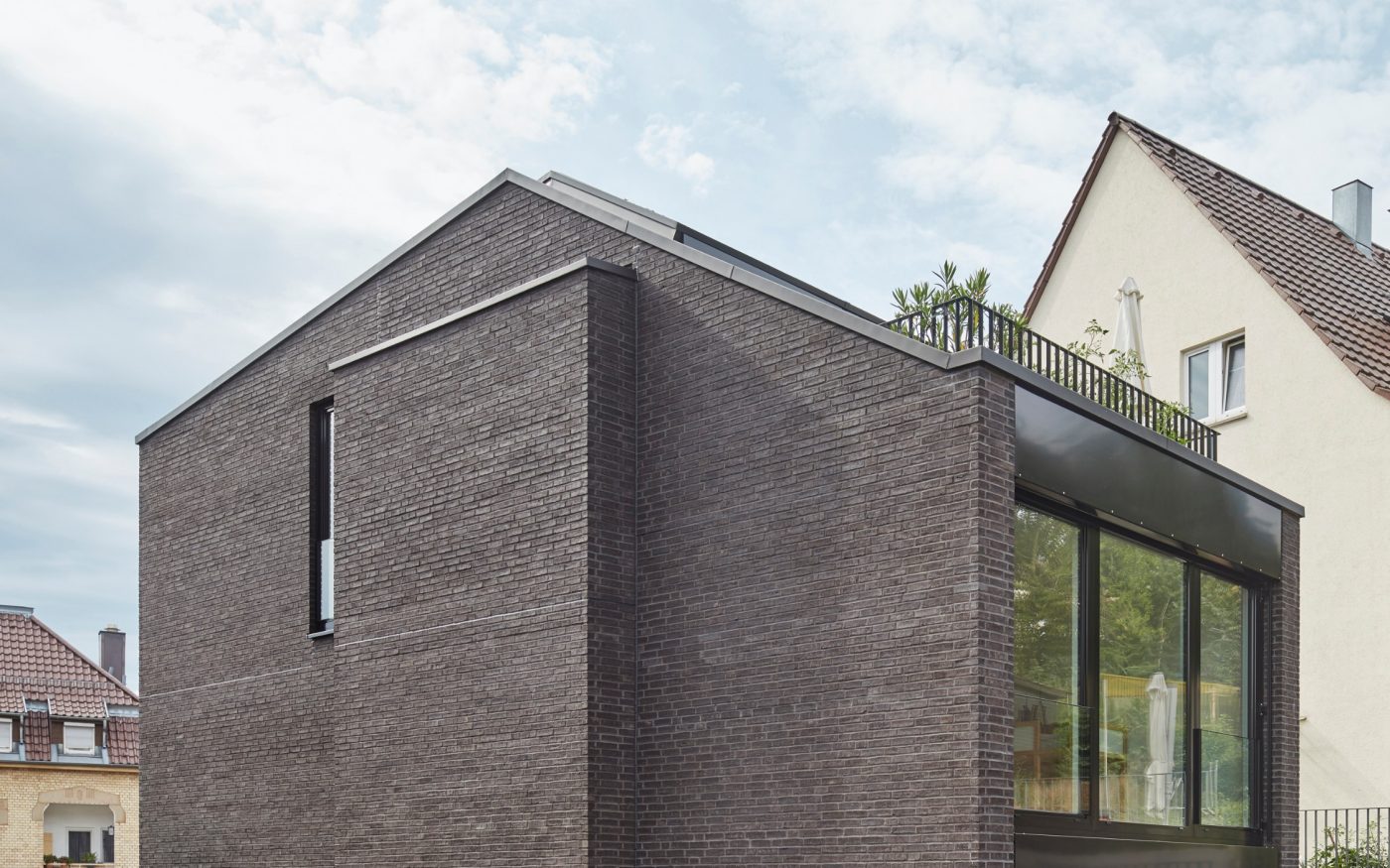 Auf der Nordseite schiebt sich ein fast gebäudehoher Erker aus der Klinkerfassade.