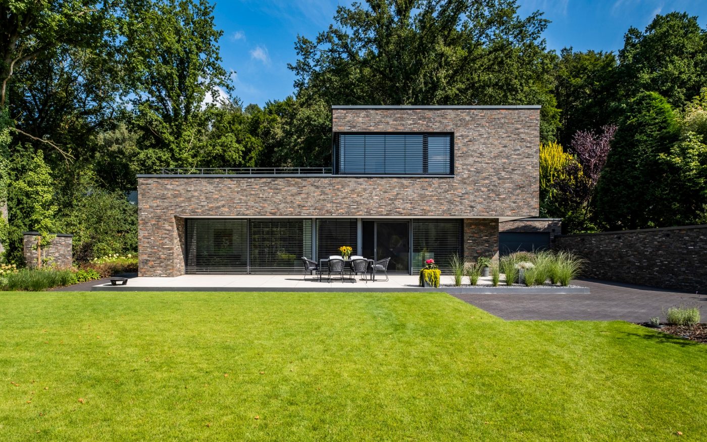 Vom Garten aus präsentiert sich das Haus mit seiner schlichten Kubatur von seiner besten Seite. Über die Südterrasse öffnet sich der Wohnbereich übergangslos in den Garten hinein.